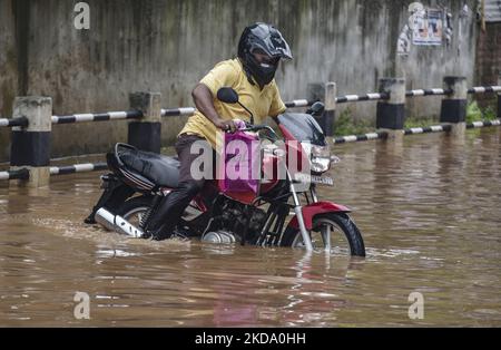 Pendler machen sich am 14. Mai 2022 nach heftigen Regenfällen in Guwahati, Assam, Indien, auf eine Wasserstraße auf den Weg. (Foto von David Talukdar/NurPhoto) Stockfoto