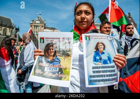 Eine Frau hält Bilder des palästinensisch-amerikanischen Journalisten Shireen Abu Aklei von israelischen Streitkräften während des palästinensischen Flaggen-marsches, der am 15.. Mai 2022 in Amsterdam organisiert wurde. (Foto von Romy Arroyo Fernandez/NurPhoto) Stockfoto