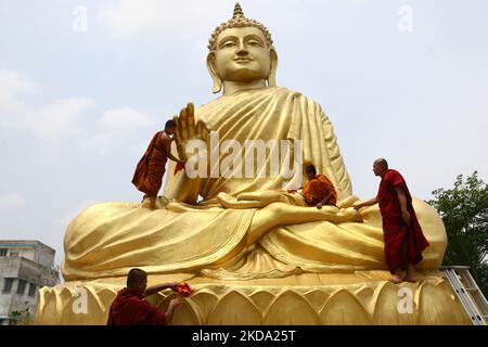 Ein indischer buddhistischer Mönch klettert auf eine riesige Buddha-Statue, um sich am Vorabend von Buddha Purnima zu waschen und zu schmücken, einem traditionellen Feiertag, der am 15. Mai 2021 in Howrah, Westbengalen, Indien, zum Geburtstag Buddhas, auch bekannt als Vesak-Feiern, gefeiert wird.Buddha Purnima feiert den 16. Mai. (Foto von Debajyoti Chakraborty/NurPhoto) Stockfoto