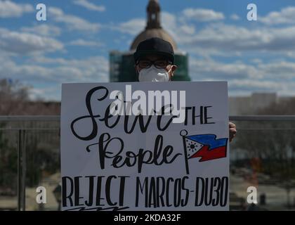 Ein Protestler hält ein Plakat mit der Aufschrift "Serve the people reject MARCOS DU3O". Mitglieder der lokalen philippinischen Jugenddiaspora (Anakbayan Alberta) protestieren vor der Alberta Legislature in Edmonton und rufen die Wahlkommission (COMELEC) auf den Philippinen wegen ihrer Fahrlässigkeit und ihres Versäumens, ehrliche und faire Wahlen vom 9. Mai 2022 zu unterstützen, auf. Die Organisatoren des Protestes sagten: „Wir verurteilen eine andere politische Dynastie mit dem Marcos-Duterte-Tandem, das das faschistische Regime unter den Filipinos fortführt“. Am Sonntag, den 15. Mai 2022, Kanada. (Foto von Artur Widak/NurPhoto) Stockfoto