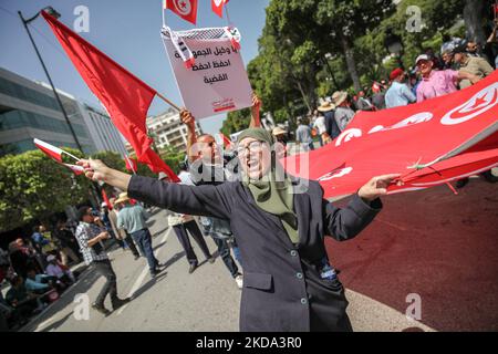 Eine Frau singt Slogans, während sie eine große Flagge Tunesiens hält, während einer Demonstration von Anhängern der Bewegung Bürger gegen den Putsch - die Demokratische Initiative, die Nationale Heilsfront und die islamistische Partei Ennahda - am 15. Mai in der Avenue Habib Bourguiba in Tunis, Tunesien, 2022 aus Protest gegen den tunesischen Präsidenten Kais Saied und seine außergewöhnlichen Maßnahmen, die er seit Juli 2021 ergriffen hat. Die Demonstranten forderten die Absetzung von Präsident Kais Saied und den Sturz des von ihnen so genannten diktatorischen Regimes und forderten die Rückkehr der demokratischen Institutionen sowie die Rückkehr zur Demo Stockfoto