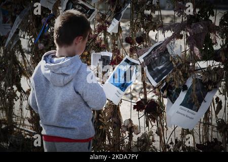 Die Menschen gehen an einer Blumenwand vorbei, auf der Bilder von ukrainischen Opfern der russischen Invasion in Warschau am 17. Mai 2022 zu sehen sind. Der Konflikt hat in der nach der UNO so genannten größten humanitären Krise in Europa seit den jugoslawischen Kriegen im Jahr 1990s etwa 8000 Tausend Tote und mehr als 6 Millionen Erwiderungen verursacht. (Foto von STR/NurPhoto) Stockfoto