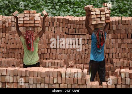 Am 18. Mai 2022 entladen Arbeiter Ziegelsteine von einem Frachtschiff im Gebiet Kamrangirchar in Dhaka, Bangladesch. (Foto von Syed Mahamudur Rahman/NurPhoto) Stockfoto