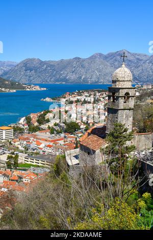 Kotor, Montenegro, Europa. Bucht von Kotor an der Adria. Kirche, Dächer der historischen Gebäude in der Altstadt. Bucht und Berge in der Stockfoto