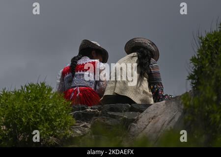 Einheimische Frauen tragen traditionelle lokale Kleider und Hüte, die auf der malerischen Aussichtsplattform Mirador Cruz del Cóndor mit Blick auf den Colca Canyon gesehen werden. Am Samstag, den 9. April 2022, in Chivay, Provinz Caylloma, Department of Arequipa, Peru. (Foto von Artur Widak/NurPhoto) Stockfoto