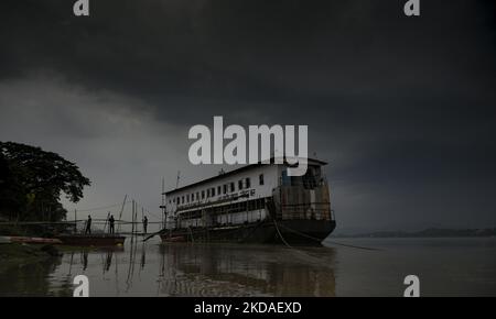 Das NDRF-Boot parkte am Ufer des Brahmaputra-Flusses, als sich am 19. Mai 2022 dunkle Wolken am Himmel sammeln, in Guwahati. FOTO: DAVID TALUKDAR. (Foto von David Talukdar/NurPhoto) Stockfoto