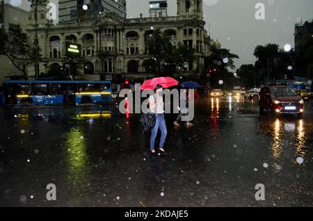 Eine Frau mit einem Regenschirm überquert eine Straße bei starken Regenfällen in Kalkutta, Indien, 21. Mai 2022. (Foto von Indranil Aditya/NurPhoto) Stockfoto