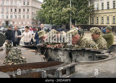 Ukrainische Militärangehörige betrachten zerstörte russische Panzerfahrzeuge, die für Ukrainer auf dem Mykhailivska-Platz in der Innenstadt von Kiew, Ukraine, ausgestellt sind, 22. Mai 2022 (Foto: Maxym Marusenko/NurPhoto) Stockfoto