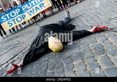 Eine Ansicht einer Frau in Veschywanka (dem traditionellen ukrainischen bestickten Hemd), die ein Kind festhält, und Putin, der mit blutigen Händen vorrückt, während einer Flashmob der ukrainischen Gemeinschaft in Rom, Italien, während einer Demonstration, die aufgerufen wurde, „keinen Krieg mehr“ zu sagen, am 22. Mai 2022 in Rom, Italien, eine Sense zu fassen. (Foto von Andrea Ronchini/NurPhoto) Stockfoto