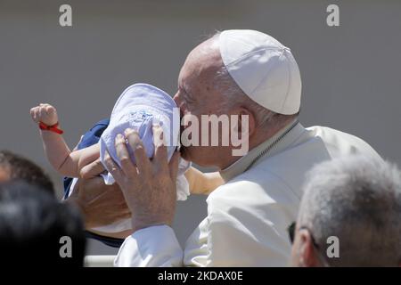 Papst Franziskus küsst ein Baby, als er am Ende seiner wöchentlichen Generalaudienz am 25. Mai 2022 auf dem Petersplatz im Vatikan abreist. Papst Franziskus sagte, er sei wegen der Schüsse an der Schule in Texas, die mindestens 19 Kinder und zwei Lehrer zum Tode brachte, „herzzerbrochen“ und verurteilte den Waffenhandel. (Foto von Massimo Valicchia/NurPhoto) Stockfoto