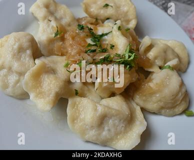 Ein Teller mit ukrainischen Pierogi (gefüllte Knödel) mit gebratenen Zwiebeln serviert an einer Milchbar in Krakau. Aufgrund der aktuellen Ereignisse in der Ukraine (2022 russische Invasion in der Ukraine) entfernen viele Gastronomen aus ganz Polen „russische Knödel“ von der Speisekarte und ändern den Namen in „ukrainische“ Knödel. Am Mittwoch, den 23. Mai 2022, fand in Krakau, der Woiwodschaft Kleinpolen, Polen. (Foto von Artur Widak/NurPhoto) Stockfoto