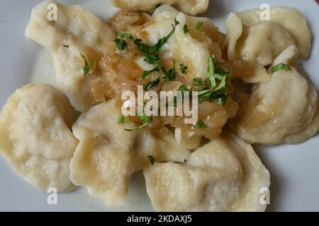 Ein Teller mit ukrainischen Pierogi (gefüllte Knödel) mit gebratenen Zwiebeln serviert an einer Milchbar in Krakau. Aufgrund der aktuellen Ereignisse in der Ukraine (2022 russische Invasion in der Ukraine) entfernen viele Gastronomen aus ganz Polen „russische Knödel“ von der Speisekarte und ändern den Namen in „ukrainische“ Knödel. Am Mittwoch, den 23. Mai 2022, fand in Krakau, der Woiwodschaft Kleinpolen, Polen. (Foto von Artur Widak/NurPhoto) Stockfoto