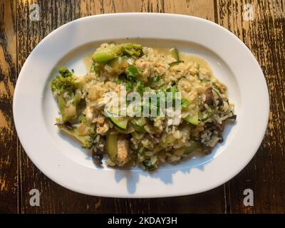 Risotto mit Hühnchen und Gemüse ist auf einem Restauranttisch auf diesem Bild zu sehen, das am 24. Mai 2022 in Krakau, Polen, aufgenommen wurde. (Foto von Jakub Porzycki/NurPhoto) Stockfoto