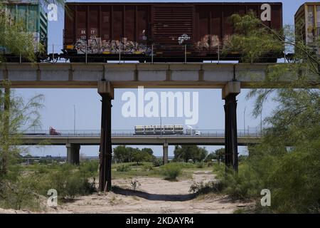 Ein Zug und ein LKW fahren am 26 2022. Mai von Mexiko in den USA in Eagle Pass Texas. Titel 42, das Mandat der Trump-Ära, das Migranten die Einreise in die USA verhindern sollte, Sollte am 23. Mai auslaufen, wurde aber durch eine Klage blockiert, die von mehreren Staaten eingereicht wurde und darauf hinweist, dass der Schritt zum Streik des Gesetzes „die Standards des Verwaltungsverfahrensgesetzes nicht erfüllt“ und dass es keine dauerhafte Lösung für den Umgang mit dem unvermeidlichen Anstieg der Einwanderung gibt. Gegner der Beanspruchung des Gesetzes brachten ihre Forderungen zum Ausdruck, dass Titel 42 illegal ist, da er gegen Einwanderungsgesetze verstößt, die Einwanderer verhindern Stockfoto