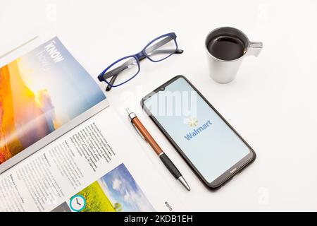 In dieser Fototafel wurde am 27. Mai 2022 ein Walmart-Logo auf einem Smartphone-Bildschirm auf einem Schreibtisch neben einem Café, einem Stift, einer Brille und einer Zeitschrift in Athen, Griechenland, angezeigt. (Fotoillustration von Nikolas Kokovlis/NurPhoto) Stockfoto