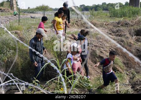 Migranten, die meisten mit Kindern, folgen einem Weg entlang des Konzertsaals, wo sie nach der Überquerung des Rio Grande am 27 2022. Mai im Eagle Pass Texas, USA, von Border Patrol unter Bewachung gestellt werden. Titel 42, das Mandat der Trump-Ära, das Migranten die Einreise in die USA verhindern sollte, Sollte am 23. Mai auslaufen, wurde aber durch eine Klage blockiert, die von mehreren Staaten eingereicht wurde und darauf hinweist, dass der Schritt zum Streik des Gesetzes „die Standards des Verwaltungsverfahrensgesetzes nicht erfüllt“ und dass es keine dauerhafte Lösung für den Umgang mit dem unvermeidlichen Anstieg der Einwanderung gibt. Gegner zum Aufhalten von Stockfoto