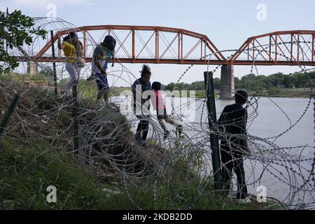 Migranten, die meisten mit Kindern, folgen einem Weg entlang des Konzertsaals, wo sie nach der Überquerung des Rio Grande am 27 2022. Mai im Eagle Pass Texas, USA, von Border Patrol unter Bewachung gestellt werden. Titel 42, das Mandat der Trump-Ära, das Migranten die Einreise in die USA verhindern sollte, Sollte am 23. Mai auslaufen, wurde aber durch eine Klage blockiert, die von mehreren Staaten eingereicht wurde und darauf hinweist, dass der Schritt zum Streik des Gesetzes „die Standards des Verwaltungsverfahrensgesetzes nicht erfüllt“ und dass es keine dauerhafte Lösung für den Umgang mit dem unvermeidlichen Anstieg der Einwanderung gibt. Gegner zum Aufhalten von Stockfoto