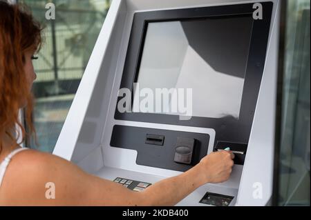 Kaukasische Frau, die Tickets von der Maschine kauft. Stockfoto