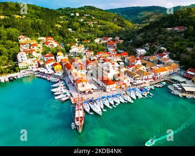 Eine Reihe leerer Boote aus der Luft am Yachthafen eines kleinen Küstendorfes mit bunten Dächern in Griechenland Stockfoto