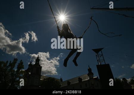 Ein junges Mädchen trainiert gerne auf der Trapezschaukel. Die Augustiner-Schwestern und die Paulinerpatres organisierten den polnisch-ukrainischen Kindertag auf einer halben Hektar großen Wiese hinter den Mauern des Klosters auf Skalka, das an die Stadt vermietet und für die Bewohner zugänglich war. Am Mittwoch, den 1. Juni 2022, in Krakau, Polen. (Foto von Artur Widak/NurPhoto) Stockfoto