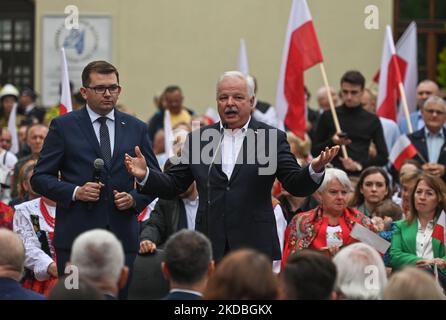 (L-R) Lukasz Kmita, der Voivode von Ma?opolska und Jacek Osuch, Staatssekretär im Ministerium für Kultur und nationales Erbe, stellen den Einwohnern von Olkusz den polnischen Ministerpräsidenten Mateusz Morawiecki vor. Mateusz Morawiecki hat sich auf den Weg gemacht, um die Polen zu treffen. Der erste Halt des polnischen Regierungsoberhauptes war Olkusz bei Krakau, wo er, nachdem er einen modernen Krankenwagen an ein örtliches Krankenhaus übergeben hatte, die Einwohner der Stadt traf. Am Samstag, den 04. Juni 2022, fand in Olkusz, Woiwodschaft Kleinpolen, Polen. (Foto von Artur Widak/NurPhoto) Stockfoto