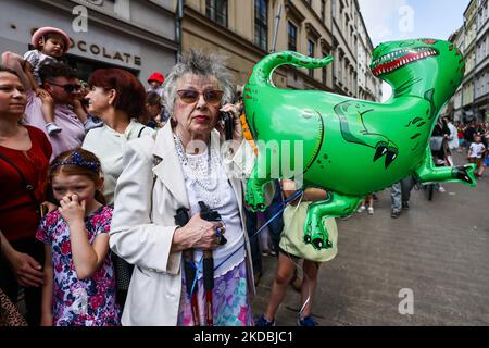 Die Menschen beobachten die große Drachenparade 21., die am 5.. Juni 2022 durch die Altstadt von Krakau, Polen, marschiert. Die jährliche Parade der Großen Drachen umfasst mehr als tausend Teilnehmer, meist Kinder, die an der farbenfrohen Veranstaltung mit verschiedenen selbstvorbereiteten Drachenwesen teilnehmen. (Foto von Beata Zawrzel/NurPhoto) Stockfoto