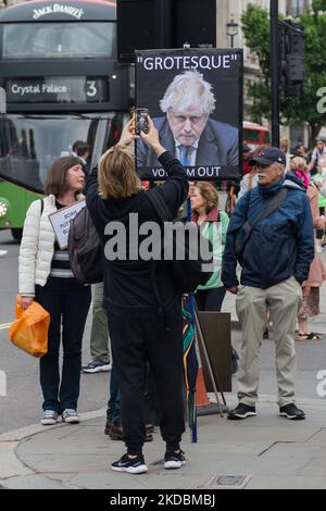 LONDON, VEREINIGTES KÖNIGREICH - 06. JUNI 2022: Ein Demonstranten hält ein Plakat vor dem Parlamentsgebäude, während Abgeordnete der Konservativen Partei am 06. Juni 2022 in London, England, bei einer Vertrauensabstimmung vor Premierminister Boris Johnson ihre Stimme abgegeben haben. Das Vertrauensvotum wurde ausgelöst, nachdem mindestens 54 Abgeordnete ihre Misstrauensbriefe an Sir Graham Brady, den Vorsitzenden des konservativen Ausschusses 1922 für die Hinterbank, eingereicht hatten, nachdem Sue Grays Bericht in Covid-Sperrparteien in der Downing Street veröffentlicht worden war. (Foto von Wiktor Szymanowicz/NurPhoto) Stockfoto