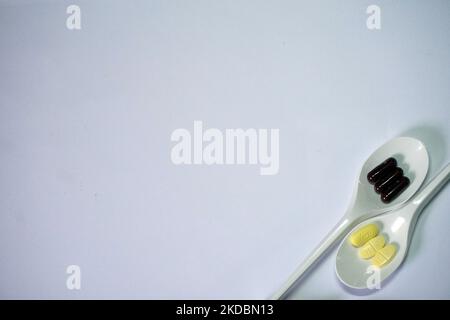 Die zwei Arten von Pillen im Löffel für medizinische Zwecke isoliert auf weißem Hintergrund Stockfoto
