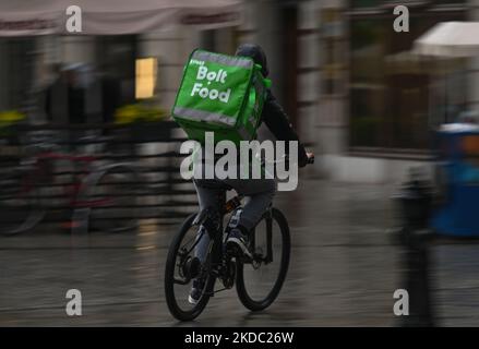 Der Bolt Food-Kurier fährt an einem regnerischen Nachmittag in Krakau mit dem Fahrrad durch den Marktplatz. Am Sonntag, den 13. Juni 2021, in Dublin, Irland. (Foto von Artur Widak/NurPhoto) Stockfoto