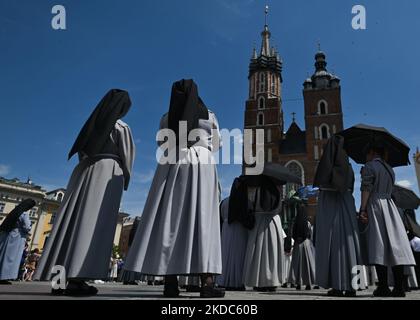 Mitglieder der örtlichen Frauenkongregationen während der Fronleichnamfeier auf dem Krakauer Marktplatz. Das Fronleichnamsfest, auch bekannt als Hochfest des heiligsten Leibes und Blutes Christi, ist eine katholische liturgische Feierlichkeit, die die wahre Gegenwart von Leib und Blut, Seele und Göttlichkeit Jesu Christi in den Elementen der Eucharistie feiert. Am Donnerstag, den 16. Juni 2022, in Krakau, Polen. (Foto von Artur Widak/NurPhoto) Stockfoto