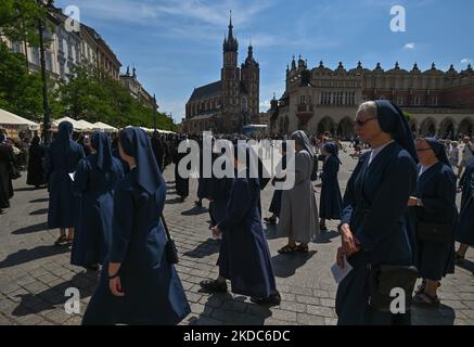 Mitglieder der örtlichen weiblichen religiösen Gemeinden marschieren während der Fronleichnamsprozession auf dem Krakauer Marktplatz. Das Fronleichnamsfest, auch bekannt als Hochfest des heiligsten Leibes und Blutes Christi, ist eine katholische liturgische Feierlichkeit, die die wahre Gegenwart von Leib und Blut, Seele und Göttlichkeit Jesu Christi in den Elementen der Eucharistie feiert. Am Donnerstag, den 16. Juni 2022, in Krakau, Polen. (Foto von Artur Widak/NurPhoto) Stockfoto