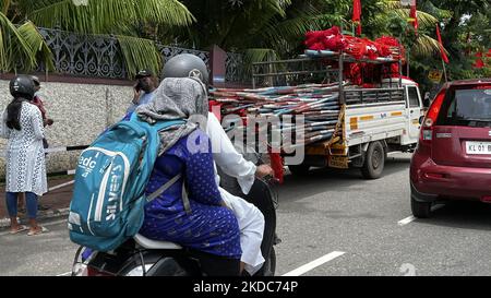 Die Menschen fahren an einem Lastwagen vorbei, der mit Fahnen und Spruchbändern gefüllt ist, um sich auf die Vaikunda Swami Dharma Pracharana Sabha (VSDP) vorzubereiten, eine prominente Gruppe der Nadar-Gemeinde (Nadar-Kaste) in Süd-Kerala, Die am 24. Mai 2022 eine Kundgebung vor dem Gebäude des Regierungssekretariats von Kerala in Thiruvananthapuram (Trivandrum), Kerala, Indien, abhielt. Die Kundgebung und der darauffolgende Streik sollten die Regierung aufrüttler machen und sie dazu bringen, den Forderungen der VSDP und der Nadar-Gemeinde zuzugeben. (Foto von Creative Touch Imaging Ltd./NurPhoto) Stockfoto