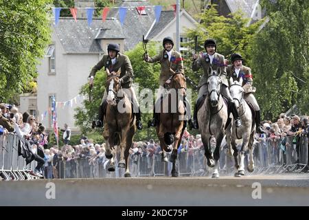 Selkirk, Großbritannien. 17.Jun.2022. Selkirk Common Riding 2022. Freitag. Die Royal Burgh-Begleiter des Standardträgers, Thomas Bell, Conall Fairbairn, Fraser Easson, Thomas Stanners galoppieren zurück zur Mautstelle, während der Burgh Standard in der Brise fliegt und die Massen an ihnen vorbei jubelt. Selkirk erinnert und feiert seine Geschichte beim jährlichen Common Riding, wenn die Stadtgrenzen oder ‘„Märsche“ geritten werden. Den Höhepunkt des Tages bildet der Brauch- und Handwerksverein der Stadt, der auf dem alten Marktplatz von Selkirk seine Farben ausgibt. (Foto von Rob Gr Stockfoto