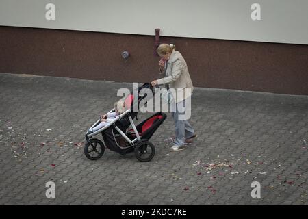 Eine Frau riecht an einem Blumensockel, den Kinder während einer Prozession am Tag nach Fronleichnam in Warschau, Polen, am 17. Juni 2022 geworfen haben. (Foto von STR/NurPhoto) Stockfoto