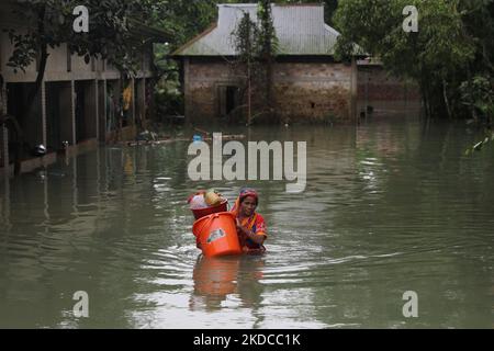 Eine Frau geht am 19. Juni 2022 nach den Sturzfluten in Goainghat Sub-distric in Sylhet, Bangladesch, durch das Hochwasser. Monsunstürme in Bangladesch und Indien haben mindestens 59 Menschen getötet und verheerende Überschwemmungen ausgelöst, die Millionen von anderen gestrandet haben, sagten Beamte. (Foto von Syed Mahamudur Rahman/NurPhoto) Stockfoto