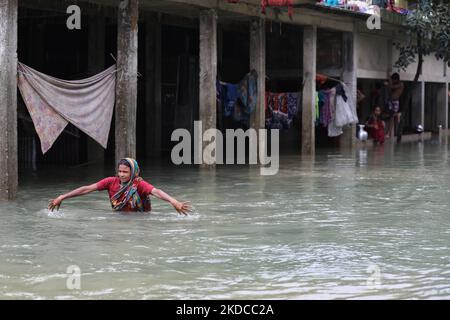 Eine Frau geht am 19. Juni 2022 nach den Sturzfluten in Goainghat Sub-distric in Sylhet, Bangladesch, durch das Hochwasser. Monsunstürme in Bangladesch und Indien haben mindestens 59 Menschen getötet und verheerende Überschwemmungen ausgelöst, die Millionen von anderen gestrandet haben, sagten Beamte. (Foto von Syed Mahamudur Rahman/NurPhoto) Stockfoto