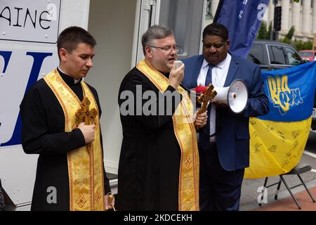 Pater Robert vom Ukrainisch Catholic National Shrine of the Holy Family, Center, spricht, während Dexter Myers, Senior Vice-President von Pacific Engineering Inc., während einer Zeremonie am Holodomor Memorial in Washington, D.C. am 21. Juni 2022 ein Megaphon hält. Ankündigung der Spende einer umfunktionierten mobilen medizinischen Klinik für Lastwagen für einen schnellen Einsatz in der Ukraine. (Foto von Bryan Olin Dozier/NurPhoto) Stockfoto