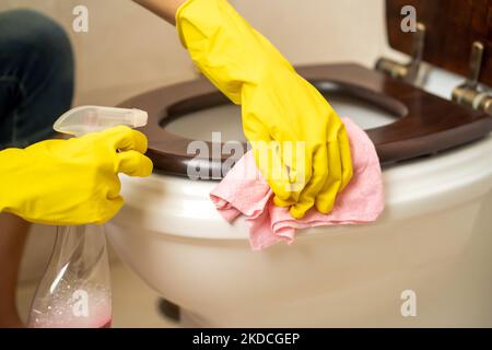 Mädchen putzt das Haus mit einem Waschmittel. Stockfoto