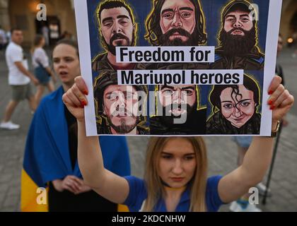 Ein Protestler hält ein Plakat mit der Aufschrift „Freiheit für Mariupol-Helden“. Mitglieder der lokalen ukrainischen Diaspora, Kriegsflüchtlinge, Friedensaktivisten, Freiwillige und lokale Unterstützer während der Demonstration „sei tapfere wie Azowstal-Helden“ zur Verteidigung der heldenhaften Soldaten von Azowstal am 122.. Kriegstag. Am Samstag, den 25. Juni 2022, auf dem Hauptmarkt in Krakau, Polen. (Foto von Artur Widak/NurPhoto) Stockfoto
