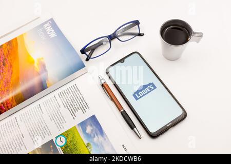 In dieser Fotolillustration wurde am 27. Juni 2022 ein Logo von Lowe auf einem Smartphone-Bildschirm auf einem Schreibtisch neben einem Café, einem Stift, einer Brille und einer Zeitschrift in Athen, Griechenland, abgebildet. (Foto von Nikolas Kokovlis/NurPhoto) Stockfoto