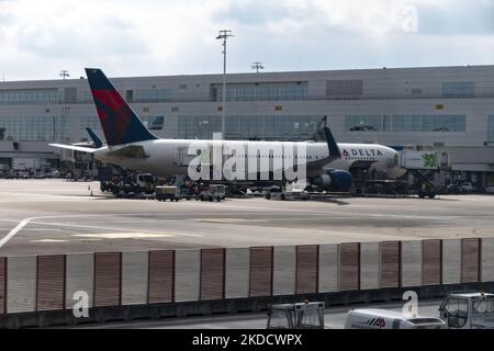 Ein Großraumflugzeug der Delta Air Lines Boeing 767, das vor dem Flughafenterminal gesehen und mit der Jetbridge verbunden ist. US-Fluggesellschaften parkten und sind mit dem Flughafenterminal des internationalen Flughafens Brüssel Zaventem in der Europäischen Hauptstadt verbunden. Die Flugzeuge werden entladen und dann wieder mit Gepäck, Treibstoff, Catering usw. beladen, um eine Umkehr in die Vereinigten Staaten von Amerika zu erreichen. Viele europäische Flughäfen litten aufgrund der Personalknappheit und der Streiks während der geschäftigen Sommerreisesaison unter Flugverspätungen und -Stornierungen Stockfoto