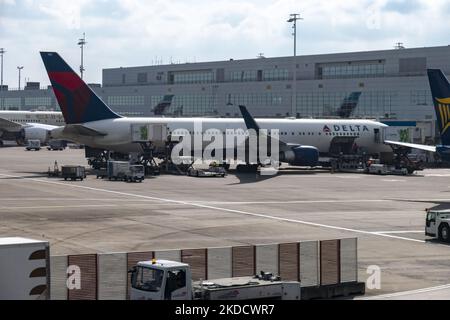 Ein Großraumflugzeug der Delta Air Lines Boeing 767, das vor dem Flughafenterminal gesehen und mit der Jetbridge verbunden ist. US-Fluggesellschaften parkten und sind mit dem Flughafenterminal des internationalen Flughafens Brüssel Zaventem in der Europäischen Hauptstadt verbunden. Die Flugzeuge werden entladen und dann wieder mit Gepäck, Treibstoff, Catering usw. beladen, um eine Umkehr in die Vereinigten Staaten von Amerika zu erreichen. Viele europäische Flughäfen litten aufgrund der Personalknappheit und der Streiks während der geschäftigen Sommerreisesaison unter Flugverspätungen und -Stornierungen Stockfoto