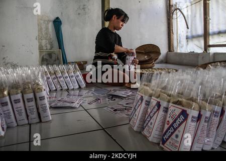 Am 29. Juni 2022 wird in Cihampelas, Cililin, West Bandung Regency, eine Frau beim Verpacken traditioneller Wajit-Lebensmittel beobachtet. West-Java, Indonesien. Die Händler sagten, dass Ende Juni 2022 der Umsatz mit traditionellen Lebensmitteln Wajit Cililin um bis zu 60 Prozent gestiegen ist oder neun Tonnen pro Monat verkaufen könnte, verglichen mit dem Vorjahr, das aufgrund von COVID-19 nur drei Tonnen pro Monat verkaufte. Wajit ist ein traditionelles Essen, typisch für Cililin, West Bandung Regency, das aus klejedem Reis, Palmzucker und Kokosnuss hergestellt wird. (Foto von Algi Febri Sugita/NurPhoto) Stockfoto