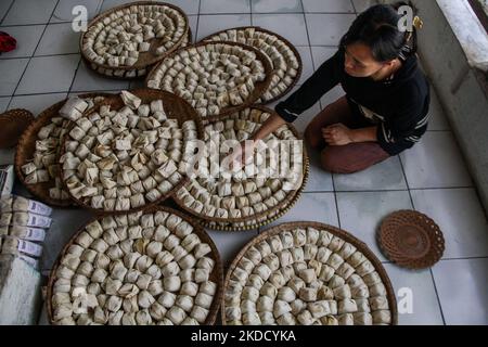 Am 29. Juni 2022 wird in Cihampelas, Cililin, West Bandung Regency, eine Frau beim Verpacken traditioneller Wajit-Lebensmittel beobachtet. West-Java, Indonesien. Die Händler sagten, dass Ende Juni 2022 der Umsatz mit traditionellen Lebensmitteln Wajit Cililin um bis zu 60 Prozent gestiegen ist oder neun Tonnen pro Monat verkaufen könnte, verglichen mit dem Vorjahr, das aufgrund von COVID-19 nur drei Tonnen pro Monat verkaufte. Wajit ist ein traditionelles Essen, typisch für Cililin, West Bandung Regency, das aus klejedem Reis, Palmzucker und Kokosnuss hergestellt wird. (Foto von Algi Febri Sugita/NurPhoto) Stockfoto