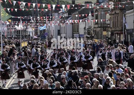 Peebles, Großbritannien - 25. Juni: Peebles Beltane - Red Letter Day Peebles Beltane Festival. Das Pipe Band führt die Kinder zur Kirchentheppe, zur Krönungszeremonie. Der Samstag ist der Höhepunkt der Woche für alle Beteiligten am Beltane. Darauf hat die Beltane Queen gewartet, seit ihr fünf Wochen zuvor mitgeteilt wurde, dass sie die gekrönte sein sollte. Dies ist der große Tag für die krönende Dame, aber vor allem ist dies der große Tag für fast fünfhundert Schulkinder, die mit Stolz Kostüme zu tragen bekommen haben, wenn sie die High Street entlang marschieren; stell dich auf die Stockfoto