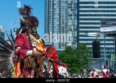 Toronto, ON, Kanada - 18. Juni 2022: Eagle Staff Carrier Bernard Nelson (gelbes Gesicht) steht vor der Menge. Zu Ehren des National Aboriginal Day fand in Fort York das traditionelle Na-Me-Res Outdoor Pow Wow statt. Das Festival feiert indigene und Metis Kultur durch traditionelle und zeitgenössische Musik, pädagogische Programme, Storytelling, Tanz, Theater, Und Essen (Foto: Anatoliy Tscherkasov/NurPhoto) Stockfoto