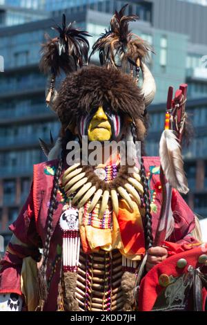 Toronto, ON, Kanada - 18. Juni 2022: Eagle Staff Carrier Bernard Nelson (gelbes Gesicht) steht vor der Menge. Zu Ehren des National Aboriginal Day fand in Fort York das traditionelle Na-Me-Res Outdoor Pow Wow statt. Das Festival feiert indigene und Metis Kultur durch traditionelle und zeitgenössische Musik, pädagogische Programme, Storytelling, Tanz, Theater, Und Essen (Foto: Anatoliy Tscherkasov/NurPhoto) Stockfoto