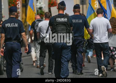 Mitglieder der lokalen Polizei kümmern sich um die Sicherheit der ukrainischen Demonstranten. Ukrainer, die in Krakau leben, wurden während ihres 133.-tägigen Protestes „NATO Close the Sky“ vor der Adam-Mickiewicz-Statue auf dem Hauptmarkt in Krakau gesehen. Am Mittwoch, den 06. Juli 2022, auf dem Hauptmarkt in Krakau, Polen. (Foto von Artur Widak/NurPhoto) Stockfoto