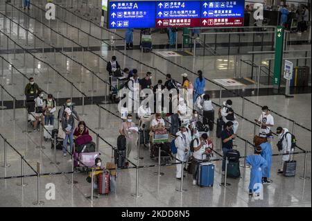 Reisende, die am 7. Juli 2022 in Hongkong, China, auf den Shuttle-Bus zu den Quarantänehotels am Internationalen Flughafen Hongkong warten. Die Regierung Hongkongs gibt bekannt, dass sie das Flugverbotsverfahren Covid-19 aussetzen wird, das Flüge mit mehr als 5 Covid-19 positiven Passagieren für fünf Tage untersagt. (Foto von Vernon Yuen/NurPhoto) Stockfoto