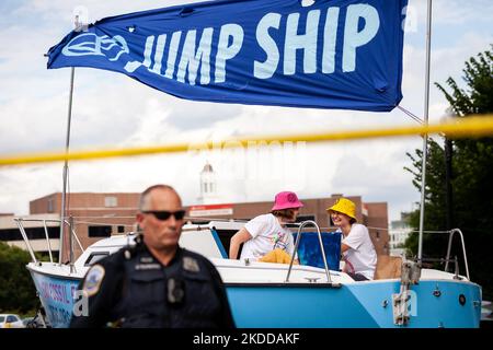 Zwei Mitglieder von Extinction Rebellion DC besetzen ein Boot, das den Verkehr hinter einem Polizisten der Metropolitan (DC) blockiert, während einer Straßenparty, die im Rahmen der Kampagne „End Methan, Electrify DC“ der Gruppe veranstaltet wird. Die Partei protestiert gegen den Ausbau der Infrastruktur für fossile Brennstoffe durch Washington Gas sowie gegen die Rolle des Unternehmens bei Methanlecks, die derzeit DC heimsuchen. Methan ist das stärkste Treibhausgas, das die globale Erwärmung antreibt und 80-mal effektiver Wärme einschließt als Kohlendioxid im Laufe von 20 Jahren. (Foto von Allison Bailey/NurPhoto) Stockfoto